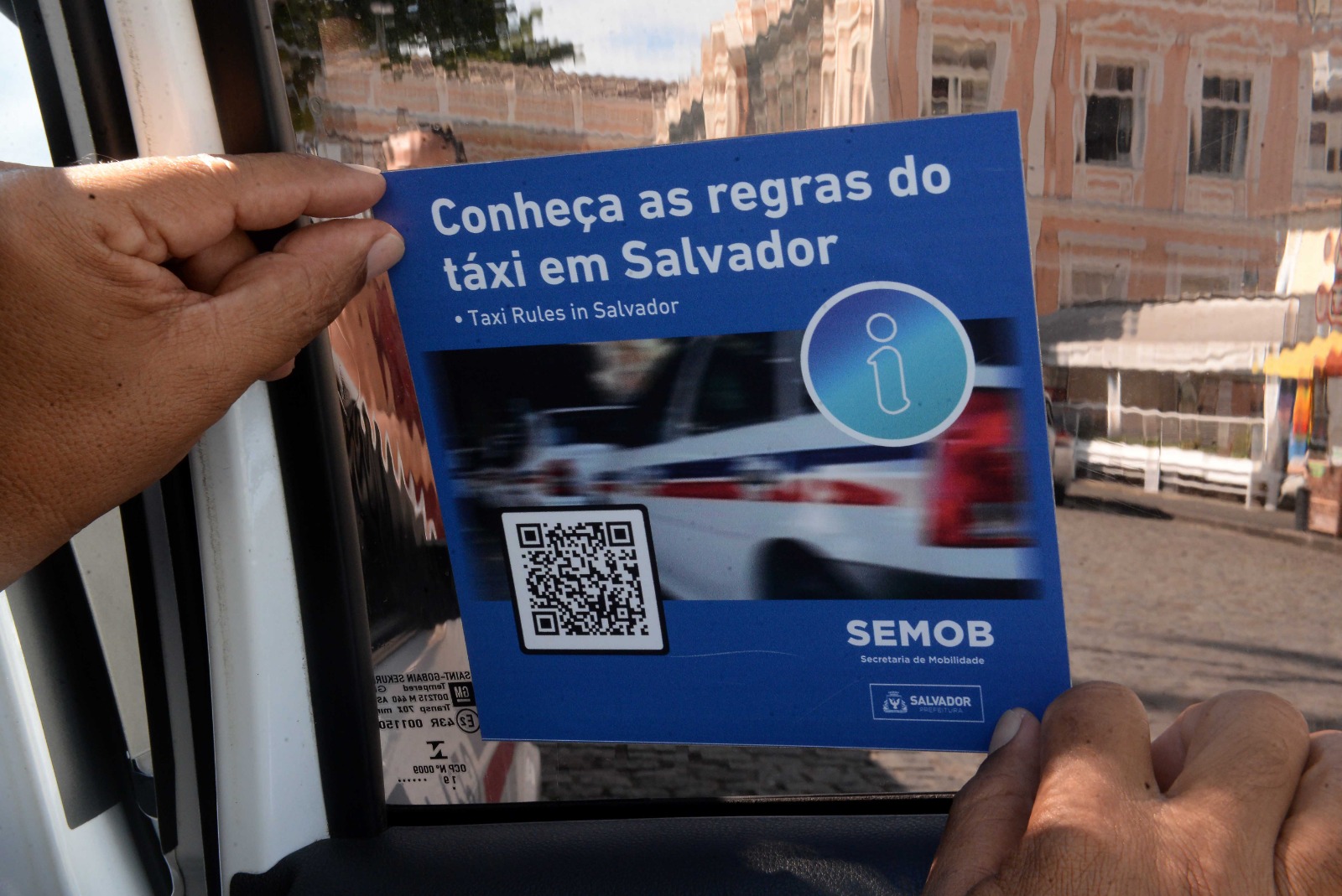 Agentes da Semob distribuem adesivos com informações sobre táxis em Salvador